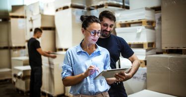 Woman and man in warehouse looking at tablet