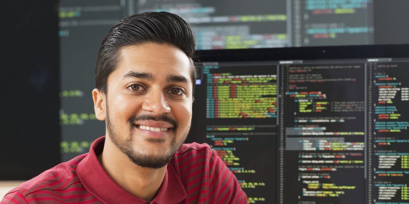 Middle Eastern businessman smiling at computer